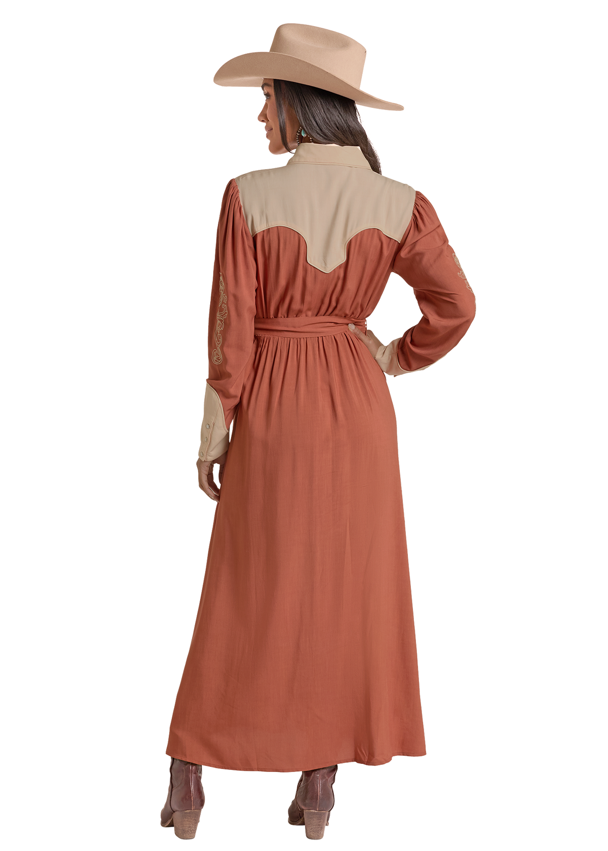 A woman shown from the back wearing a long western-style dress with a rust-orange body and beige yoke, paired with a beige wide-brim hat and brown boots, on a plain white background.