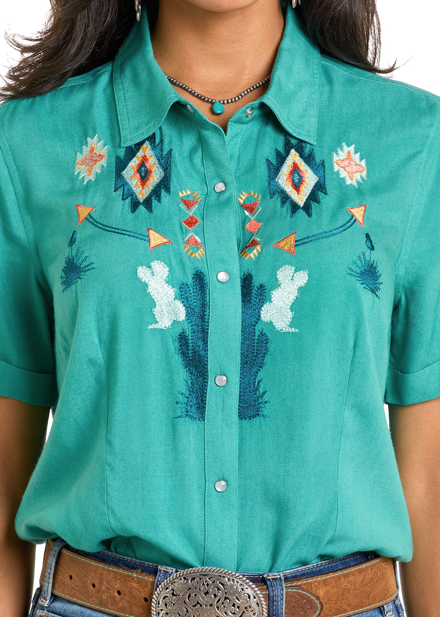 Teal shirt with embroidered designs worn by a person