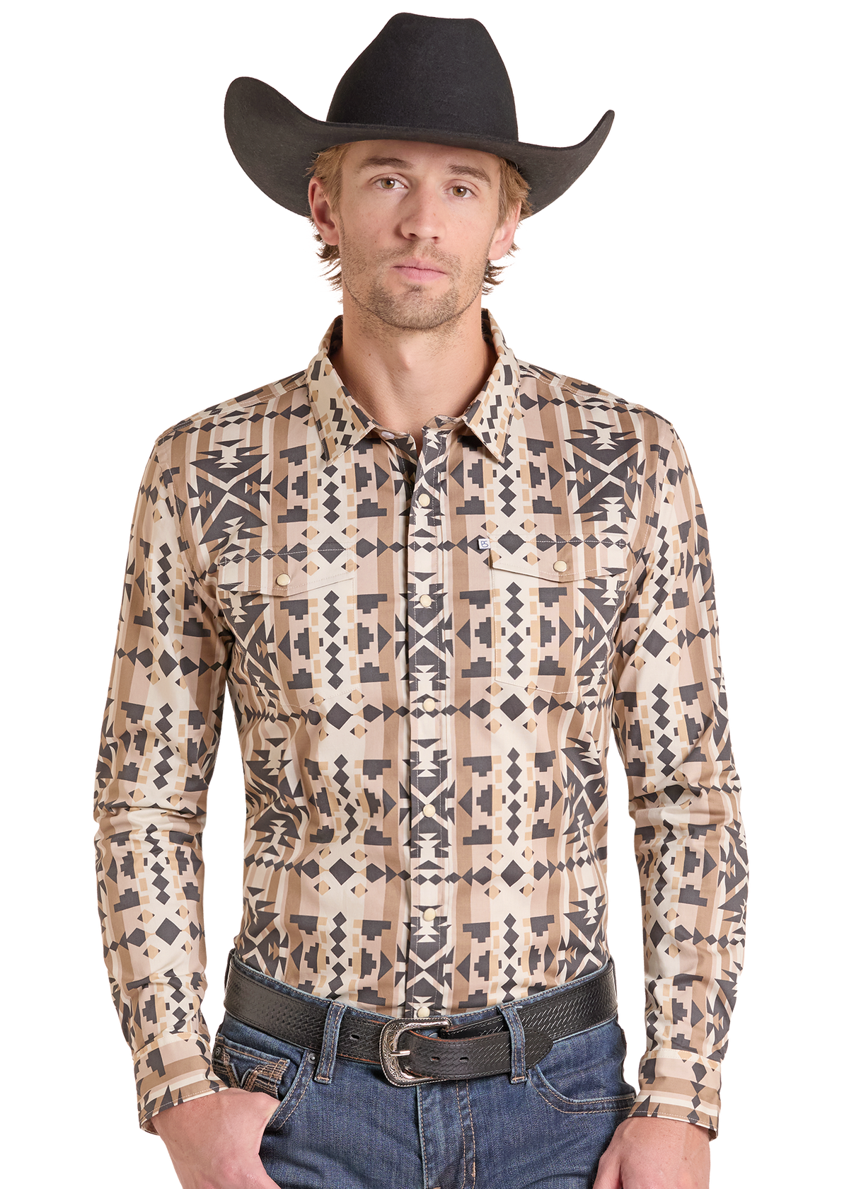 A man wearing a beige long-sleeve western button-down shirt with a black geometric pattern, a black cowboy hat, and blue jeans.