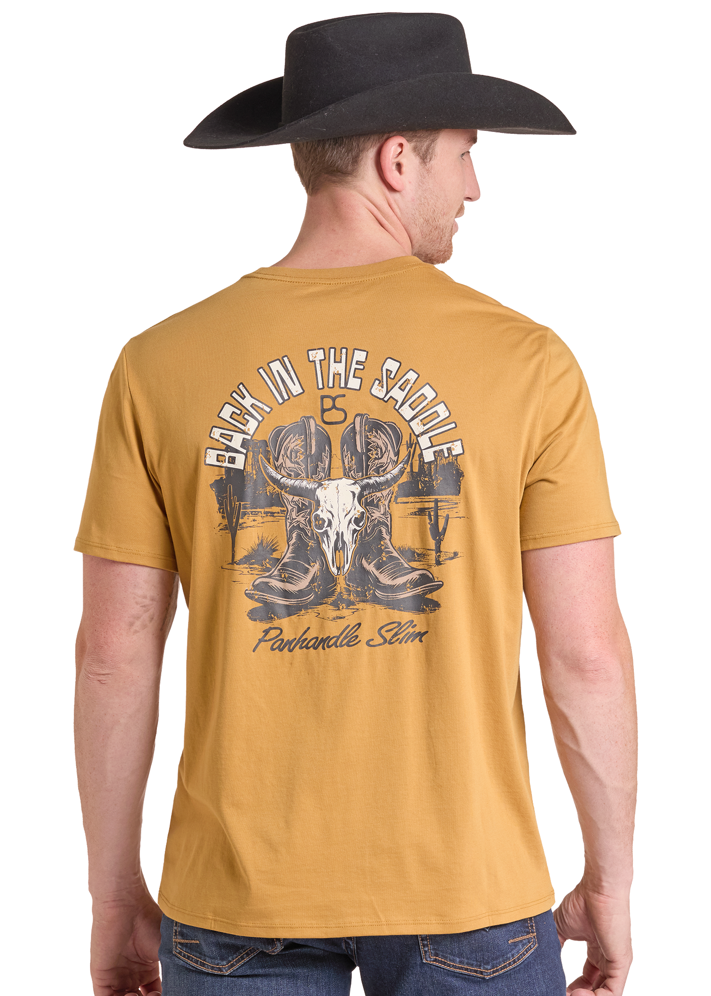 A man wearing a black cowboy hat and a mustard yellow t-shirt, viewed from the back. The t-shirt features a large graphic print on the back with a cowboy skull, boots, and the text 'BACK IN THE SADDLE' and 'Panhandle Slim'.