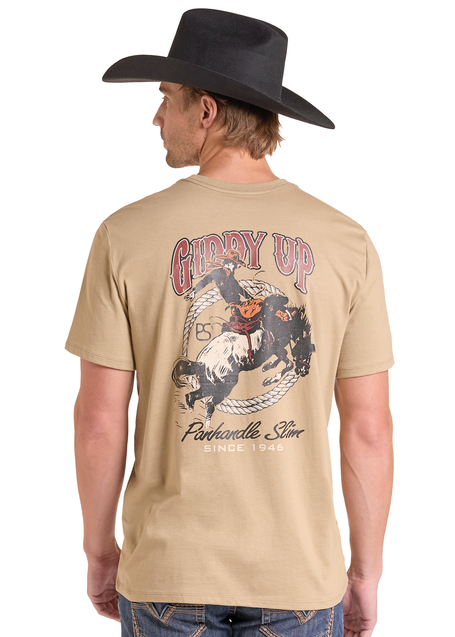 A man wearing a beige graphic t-shirt and a black cowboy hat, shown from the back. The t-shirt features a large western-themed graphic with the text 'GIDDY UP'.