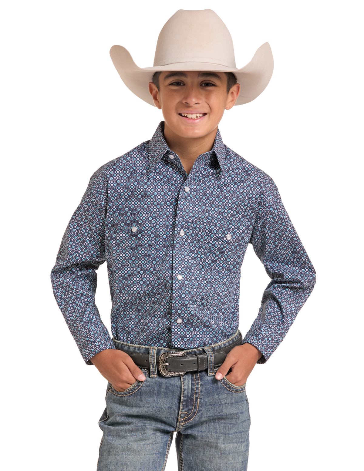 A young boy modeling a long-sleeve western-style button-up shirt with a blue, red, and white geometric pattern, paired with blue jeans and a beige cowboy hat.