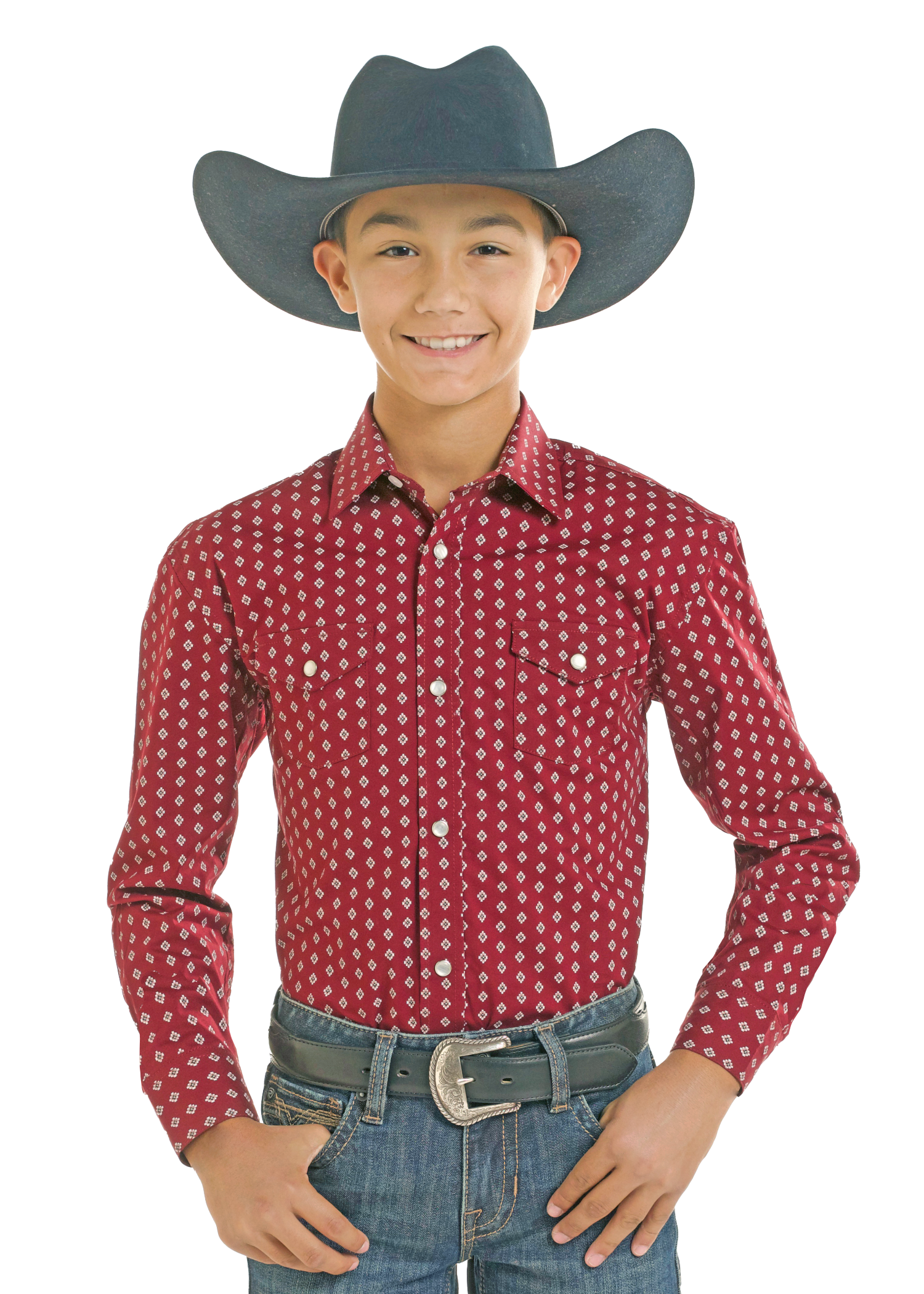 A young boy modeling a red long-sleeve western shirt with a white geometric pattern, paired with a dark gray cowboy hat, blue jeans, and a silver belt.