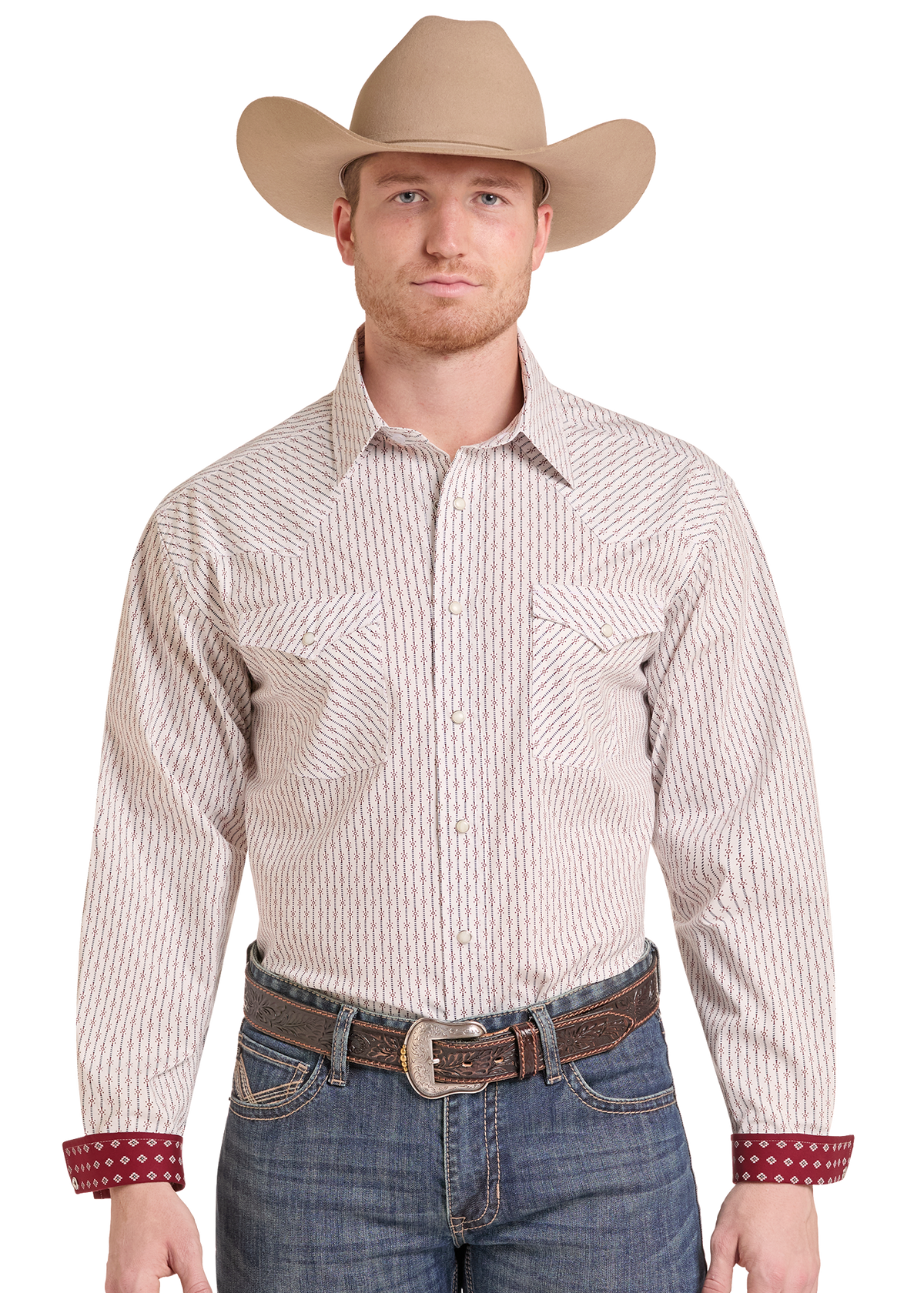 A man wearing a tan cowboy hat, a beige and brown vertically striped western long-sleeve button-down shirt, blue jeans, and a brown leather belt.