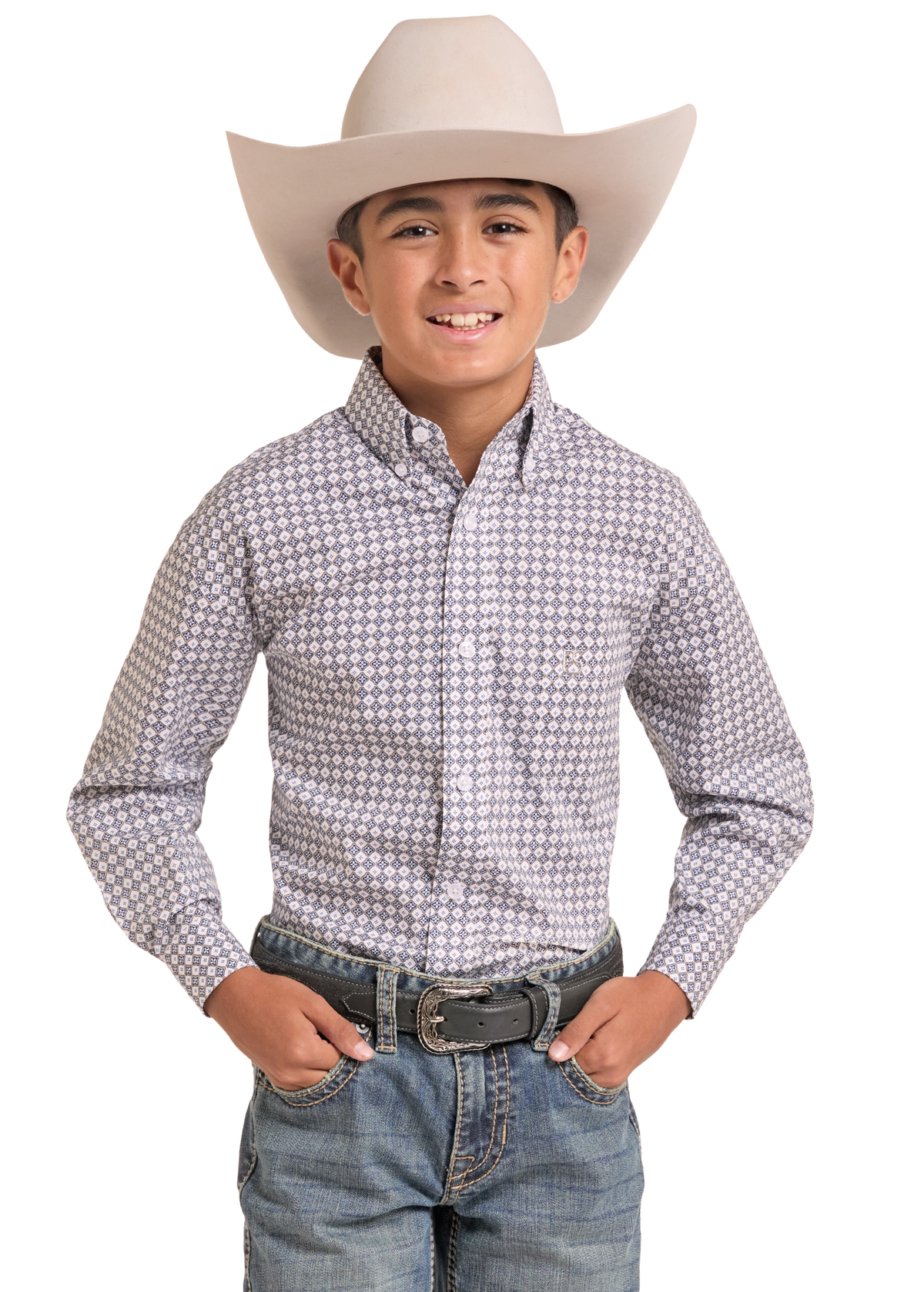 A young boy wearing a light beige cowboy hat, a long-sleeve button-down shirt with a small geometric pattern in gray and white, blue jeans, and a black belt, standing against a solid white background.