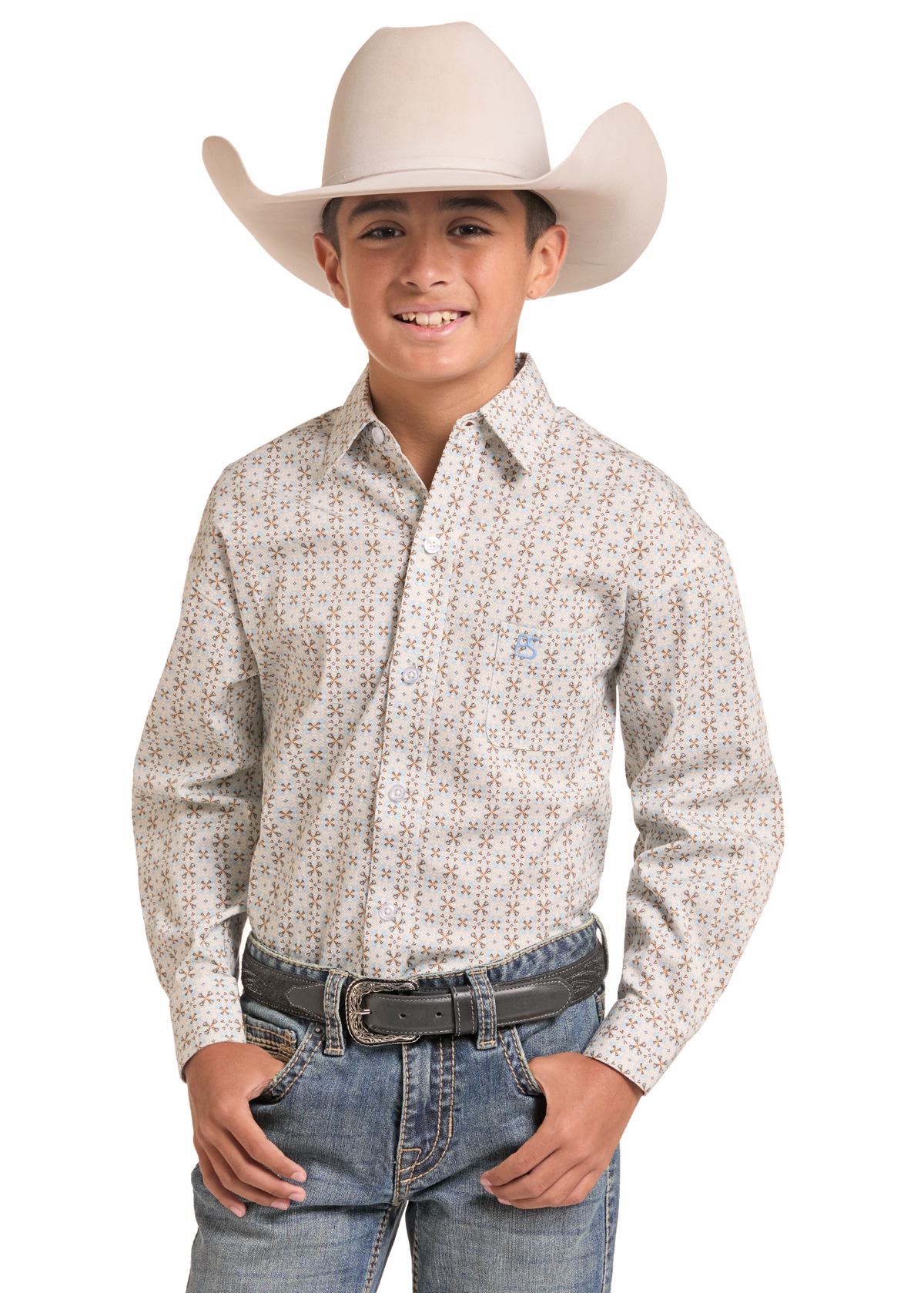 A young boy wearing a light beige cowboy hat, a long-sleeve western button-up shirt with a small geometric pattern, blue jeans, and a black belt, standing against a solid white background.