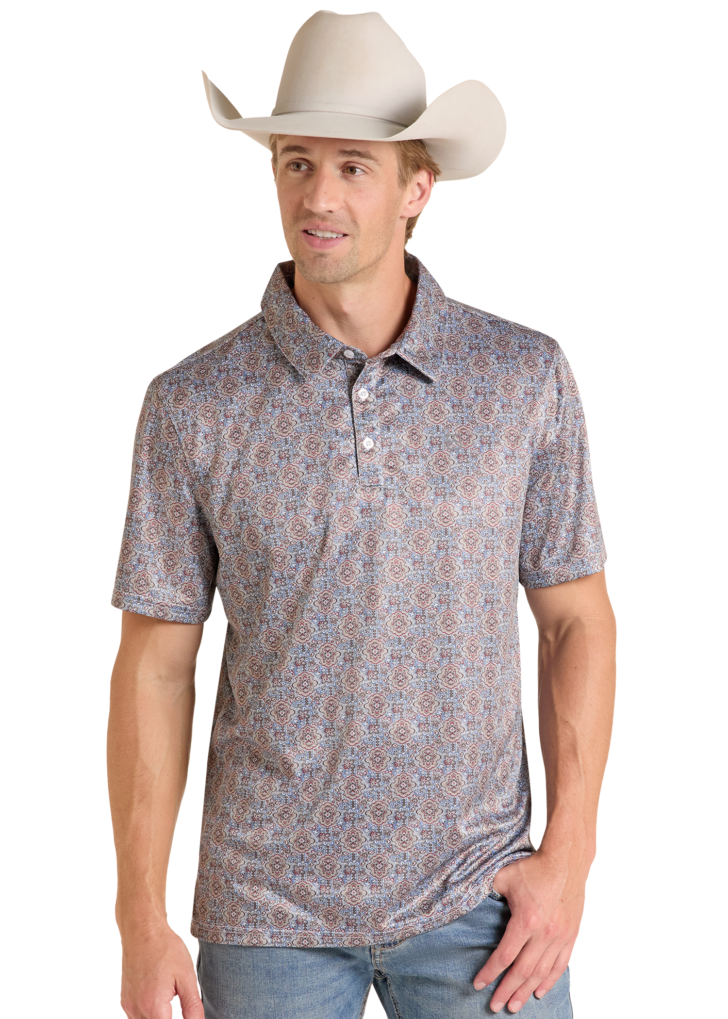 A man wearing a short-sleeve polo shirt with a dense blue, red, and beige paisley pattern, paired with a light beige cowboy hat and blue jeans, set against a plain white background.