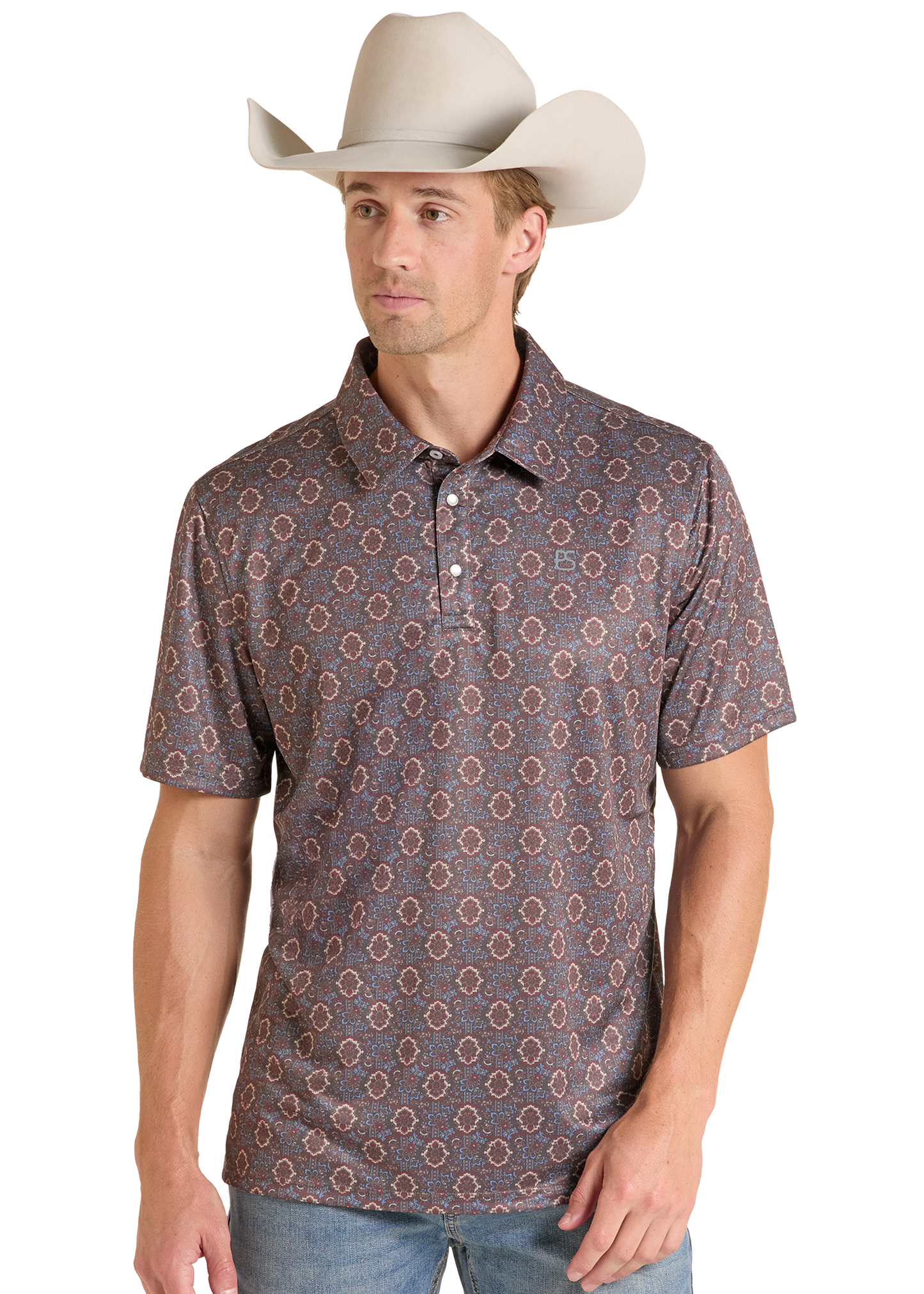 A man wearing a short-sleeve polo shirt with a brown and beige geometric pattern, paired with a light beige cowboy hat and blue jeans, photographed against a white studio background.