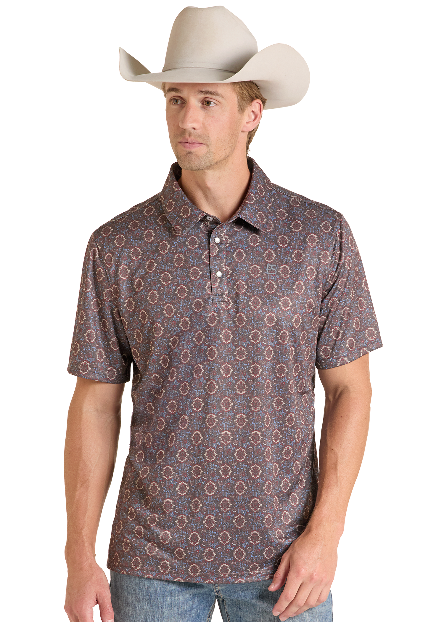 A man wearing a short-sleeve polo shirt with a brown and beige geometric pattern, paired with a light beige cowboy hat and blue jeans, photographed against a white studio background.