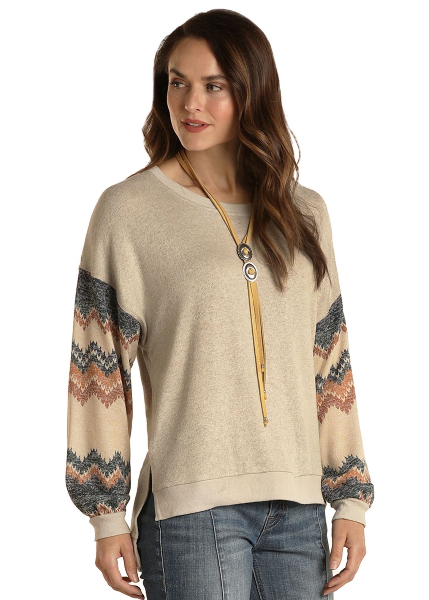 Woman wearing a beige sweater with patterned sleeves on a white background