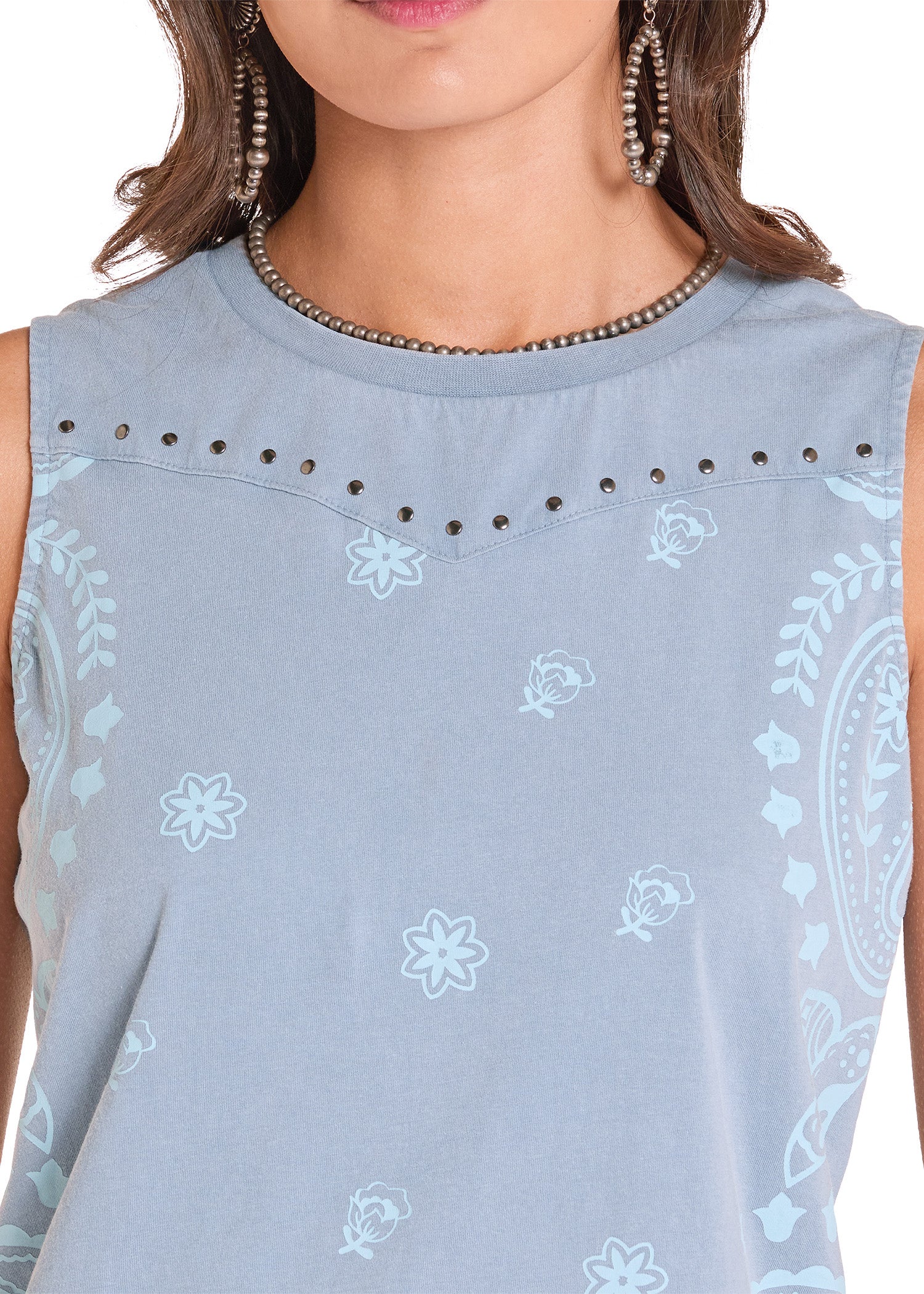 Light blue sleeveless top with floral patterns on a plain background
