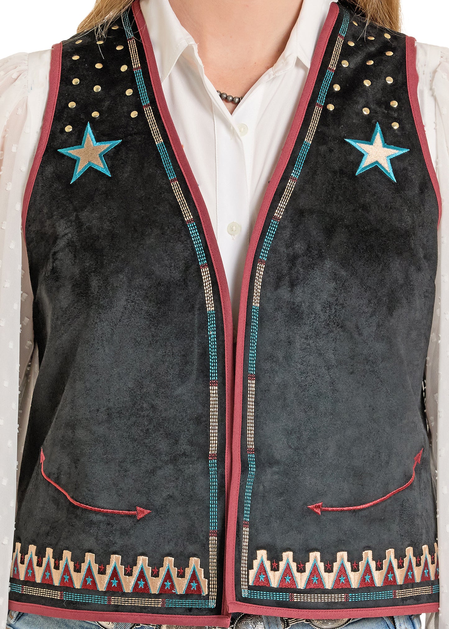 Black vest with star designs and colorful patterns on a person wearing a white shirt.