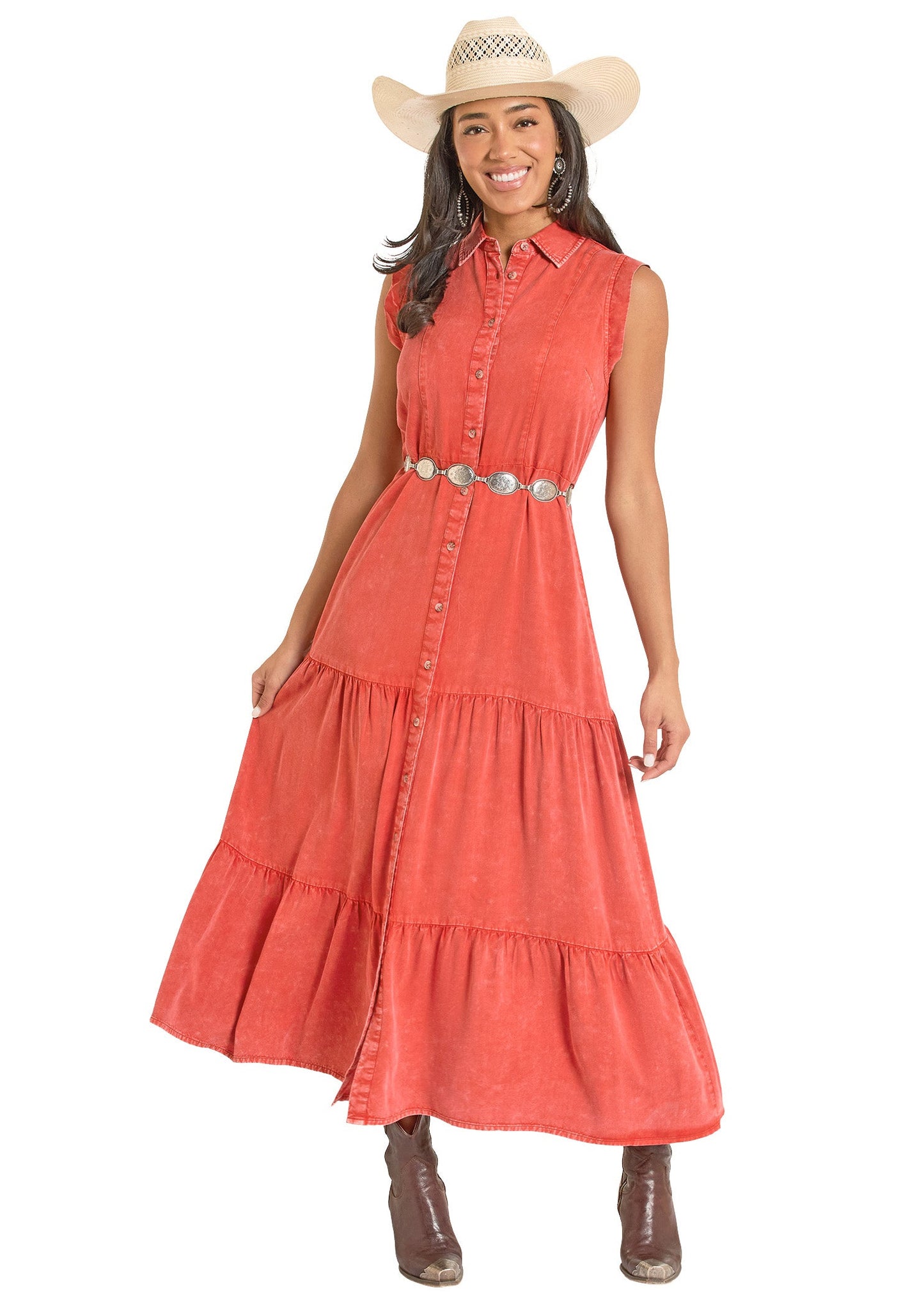 Woman wearing a coral dress with a belt and cowboy hat on a white background
