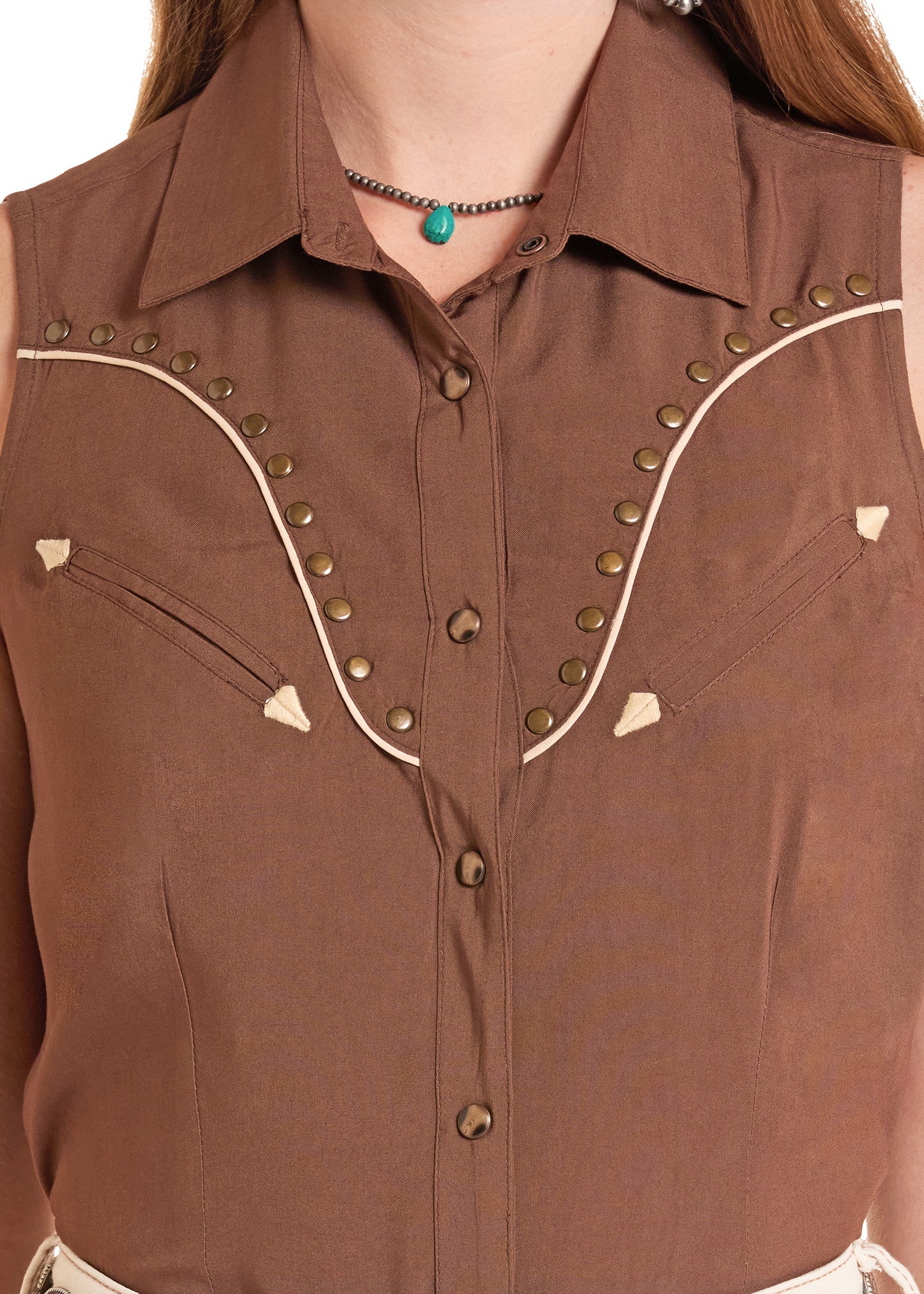 Brown sleeveless shirt with decorative buttons and trim on a white background