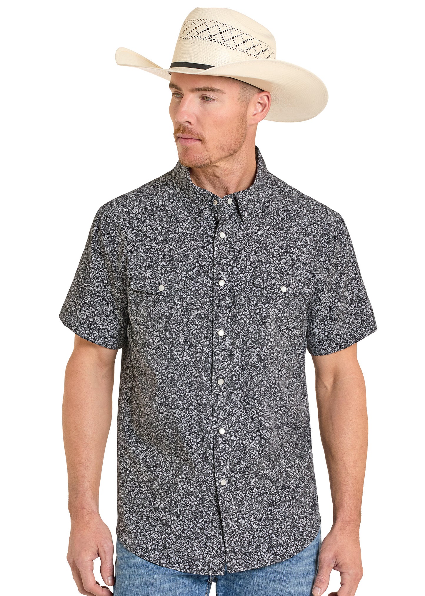 Man wearing a patterned short-sleeve shirt and cowboy hat on a white background