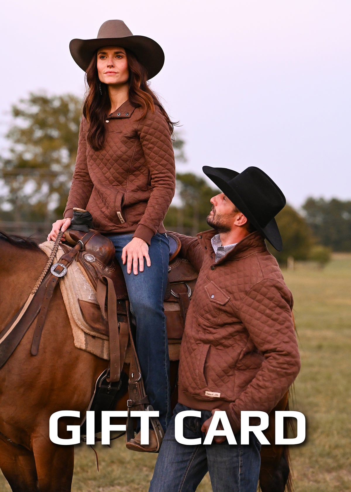 A woman on a horse and a man standing next to her. Both wearing cowboy hats, jeans and matching brown sweatshirts. "gift card" at the bottom