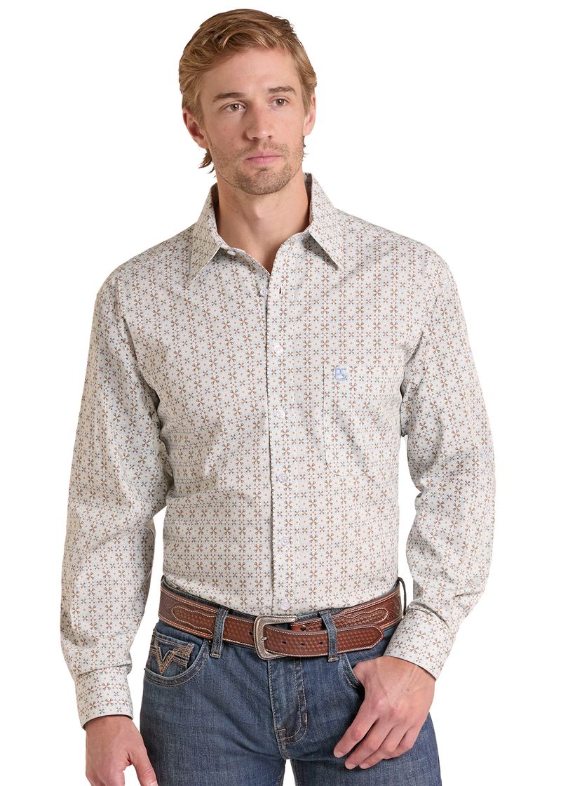 A man wearing a long-sleeve western-style button-down shirt with a small geometric pattern in beige and brown, paired with blue jeans and a brown leather belt.