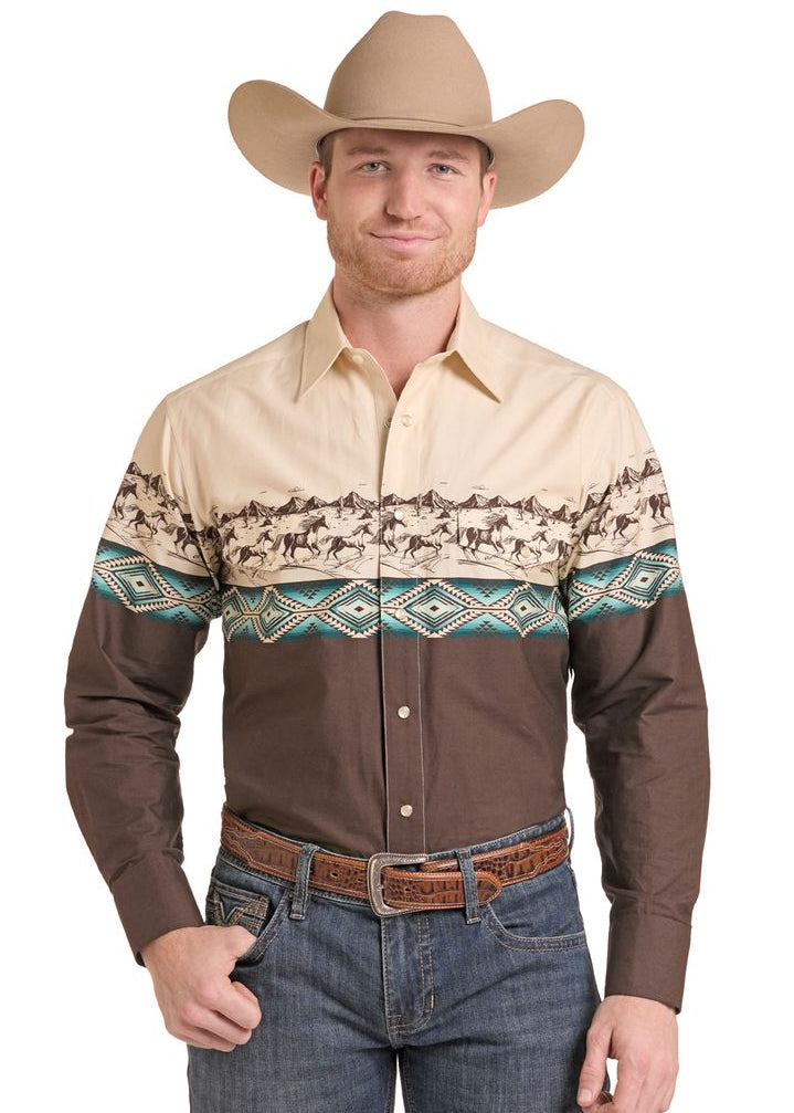 A man wearing a long-sleeve western-style snap shirt with a decorative band across the middle featuring horse and Aztec patterns.